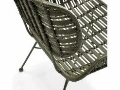 Sillón de mimbre tejido oscuro y patas de metal.^Les Tendances New